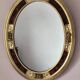 Antique medallion mirror with a gilded and relief-carved frame.