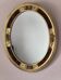 Antique medallion mirror with a gilded and relief-carved frame.