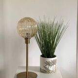 Table lamp with a gold striped globe and a gold foot