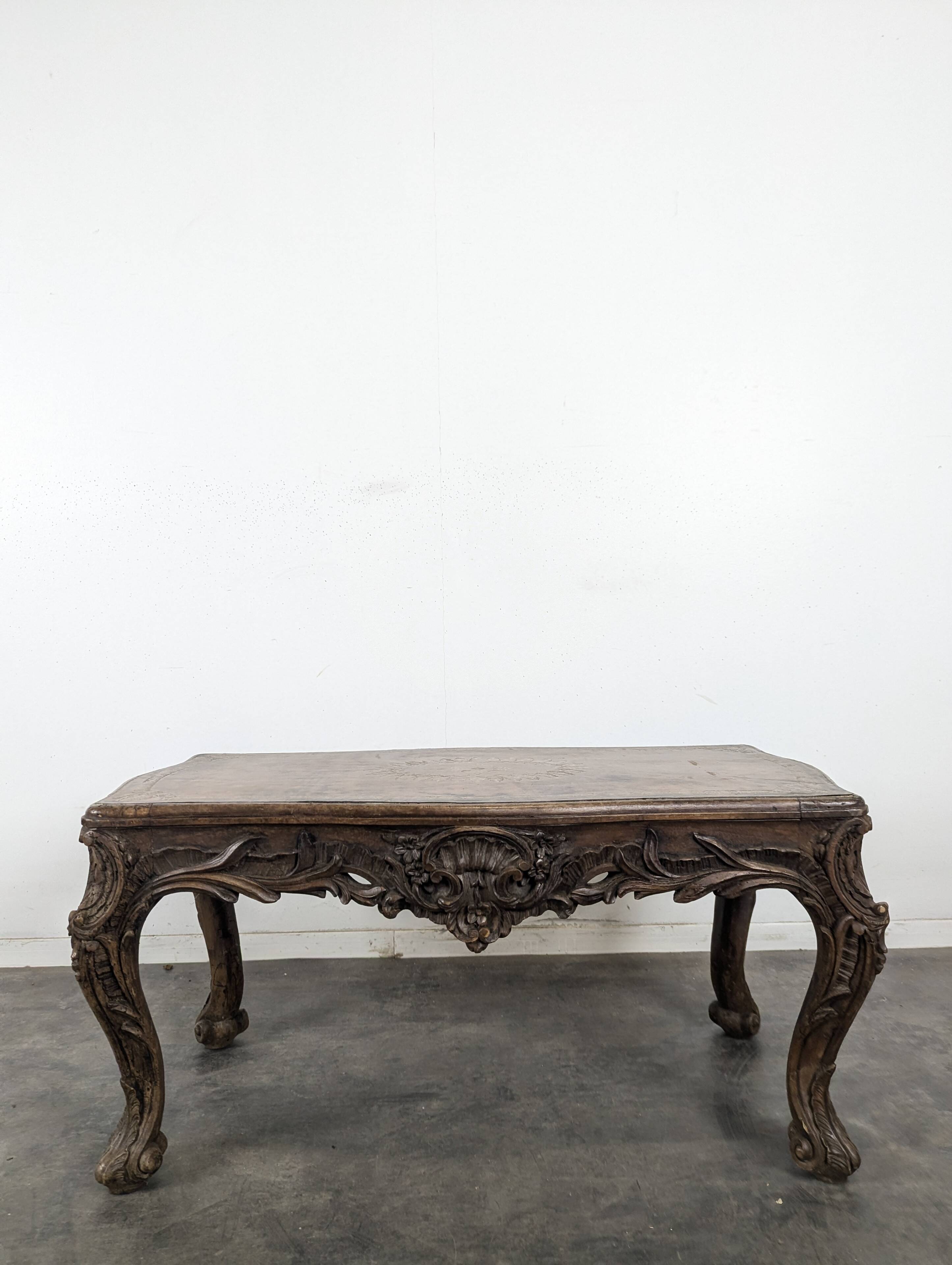 Louis XV coffee table in carved walnut with a gilded leather top.