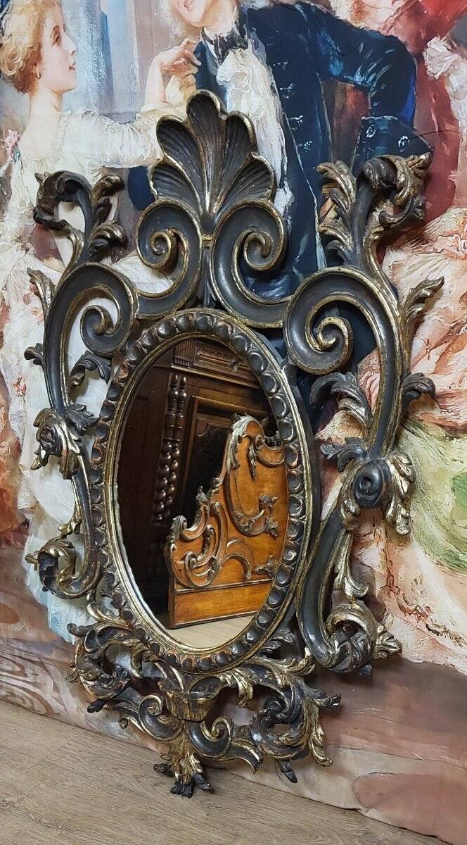 Antique Louis XV style mirror, richly carved with decorations of scrolls, shells, and foliage.