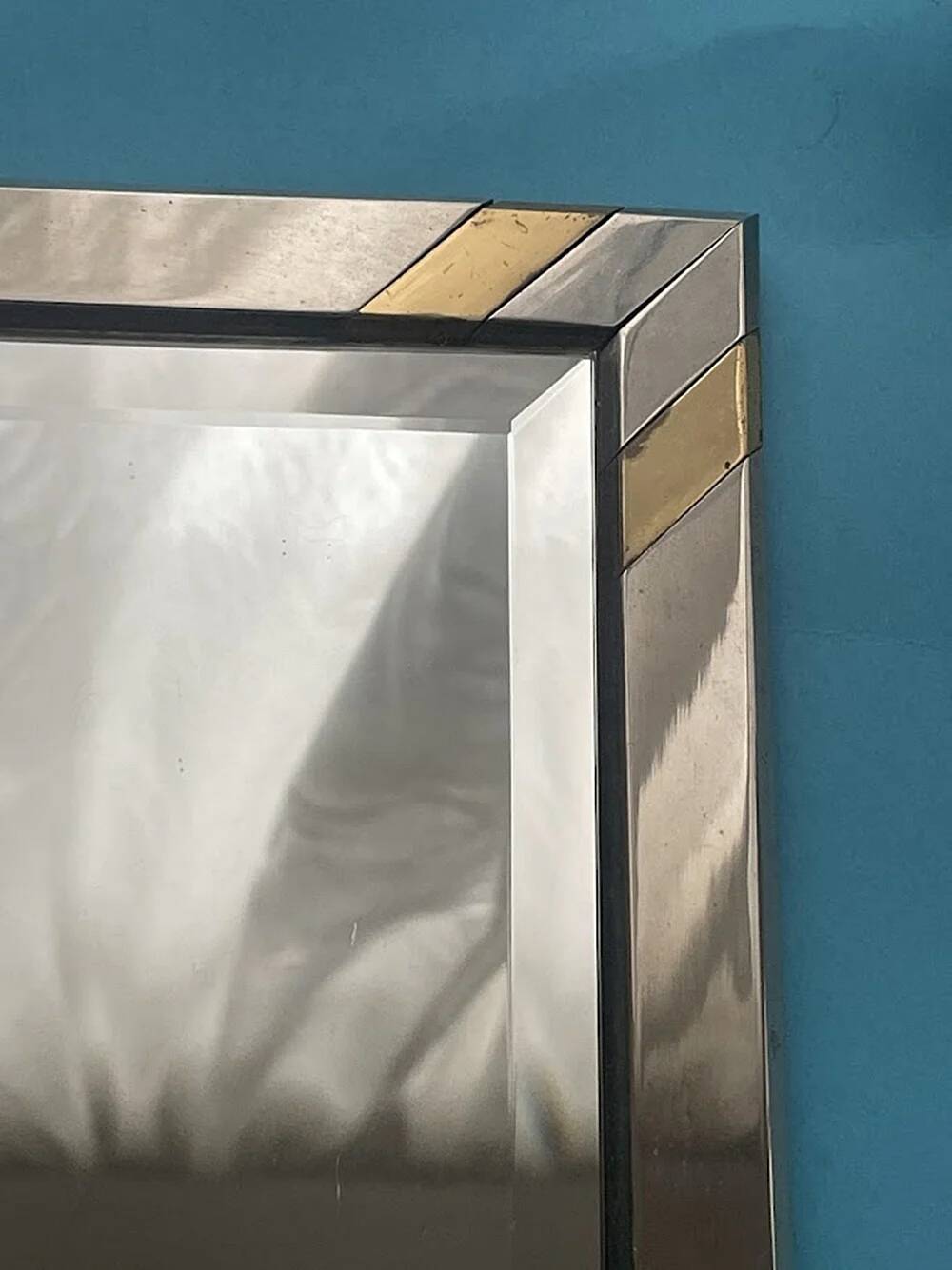 Faceted modernist wall mirror in steel and brass, geometric mixed metal frame 1970s.