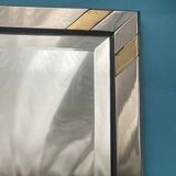 Faceted modernist wall mirror in steel and brass, geometric mixed metal frame 1970s.