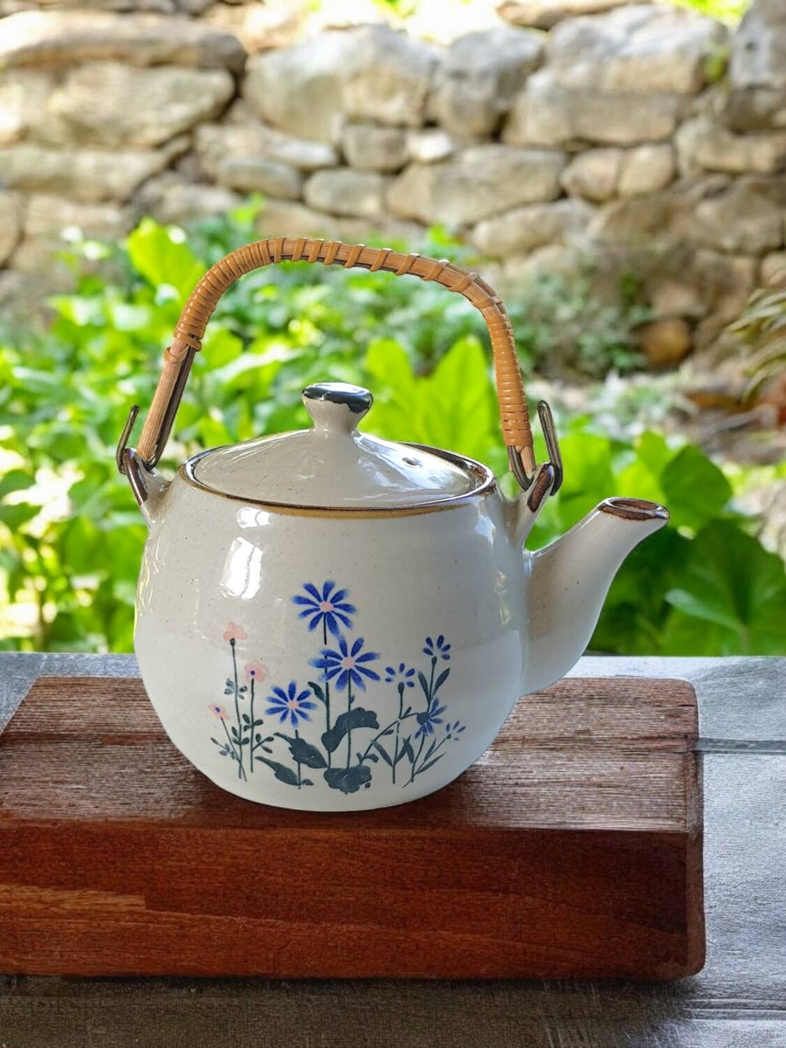 Théière en grès fleurie et anse en rotin.