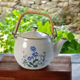 Flowery stoneware teapot with rattan handle.