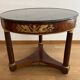 Empire gueridon in mahogany veneer adorned with chiselled and gilded bronze, topped with black marble with a groove.
