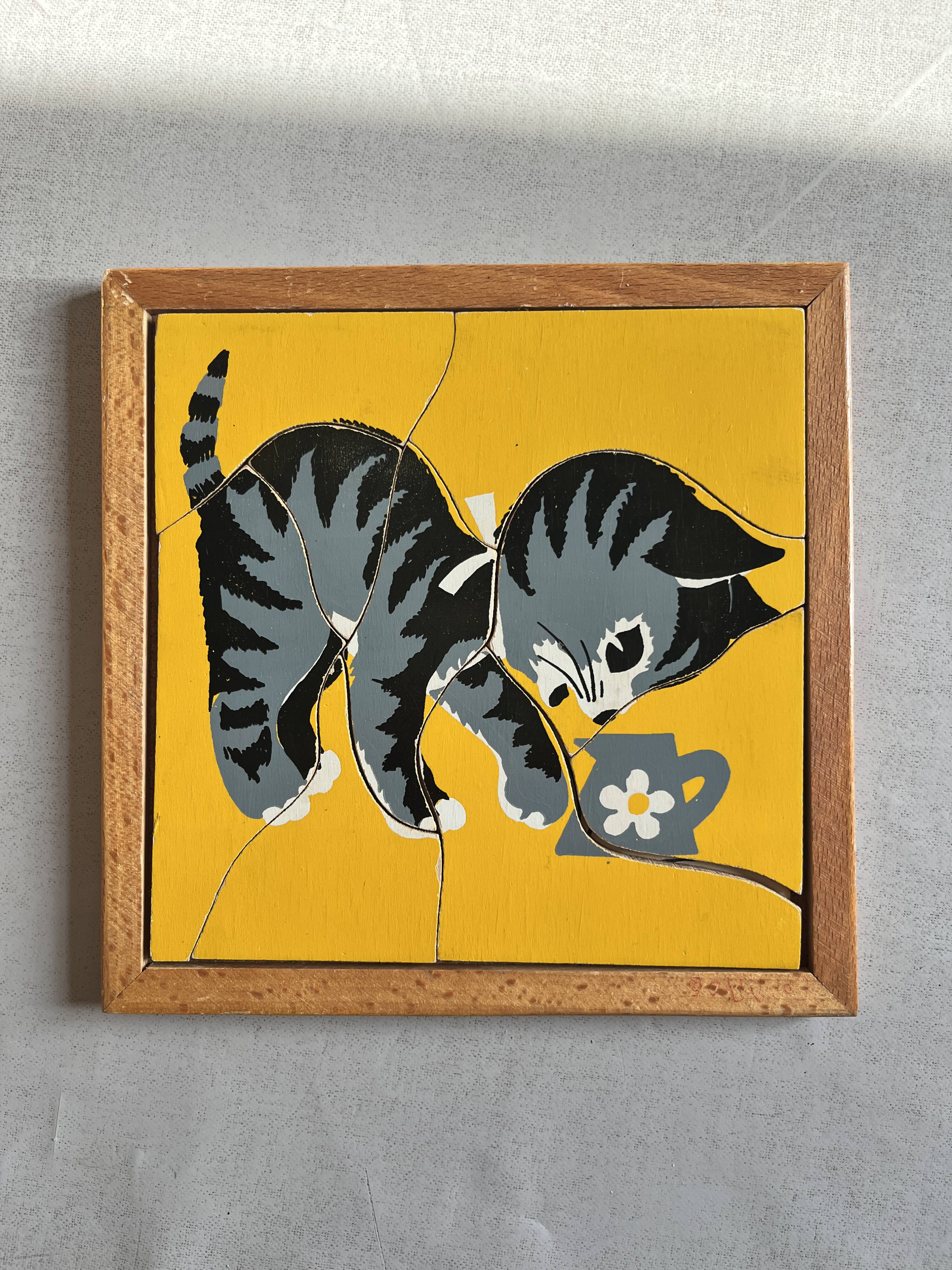 Wooden frame puzzle from the 1940s/50s depicting a cat on a yellow background.