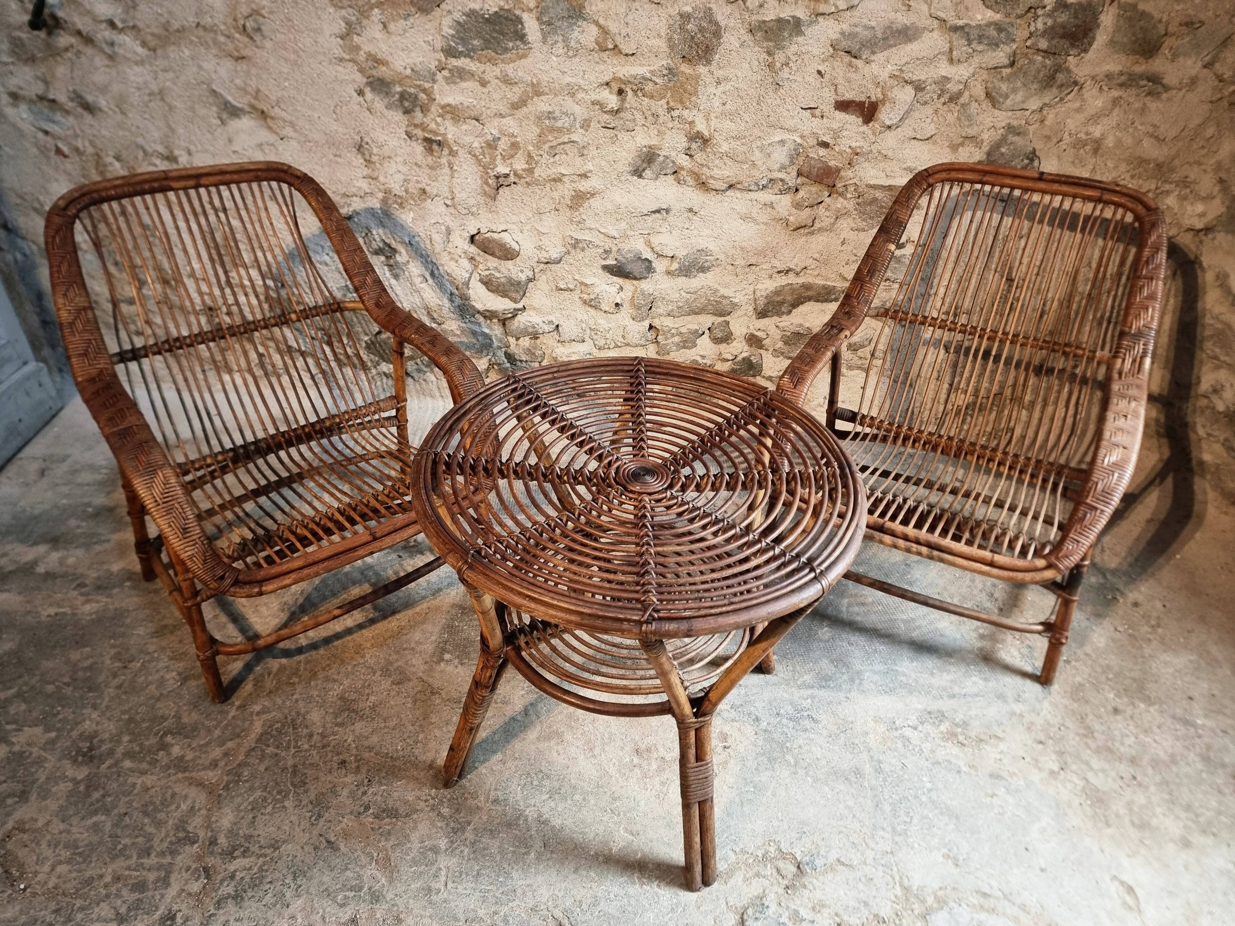 Vintage rattan lounge set, French wicker armchairs and round table, circa 1930–1950.