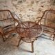 Vintage rattan lounge set, French wicker armchairs and round table, circa 1930–1950.