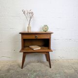 Vintage bedside table with tapered legs.
