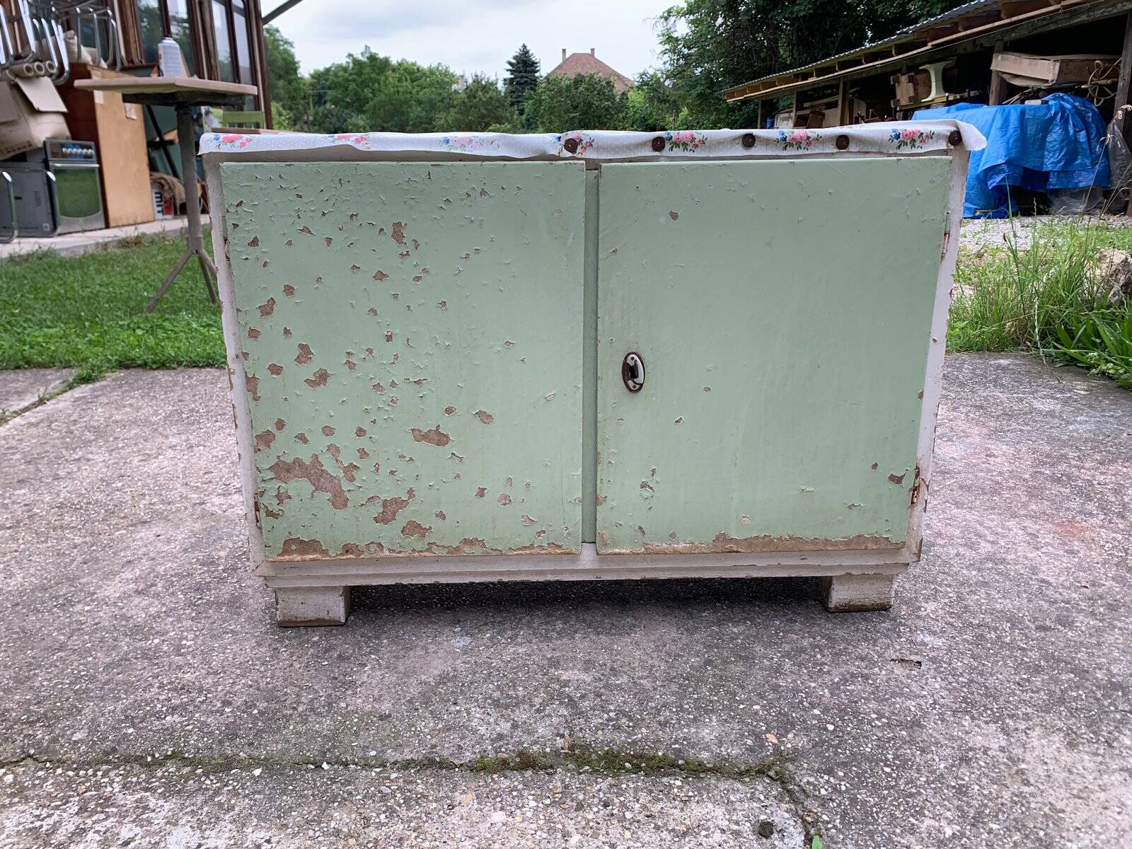Vintage low wooden cabinet painted green and white with a floral fabric top (1950s)