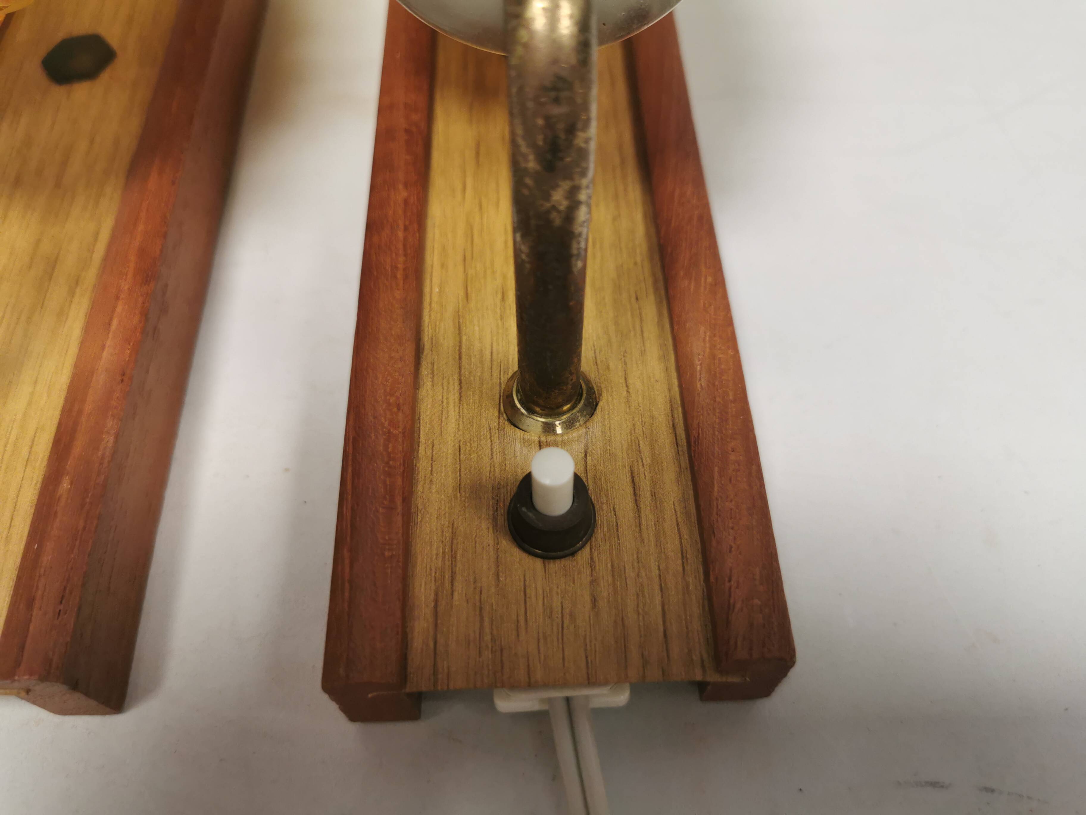 A set of wall lamps in teak wood, with amber colored glass