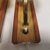 A set of wall lamps in teak wood, with amber colored glass