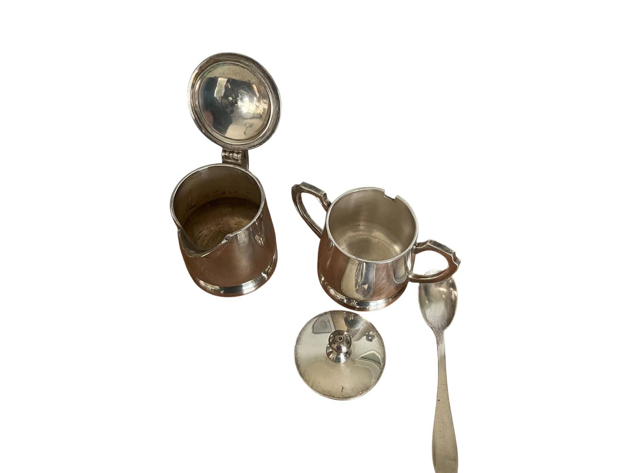 Two small silver-plated metal tea service pots from the 20th century.