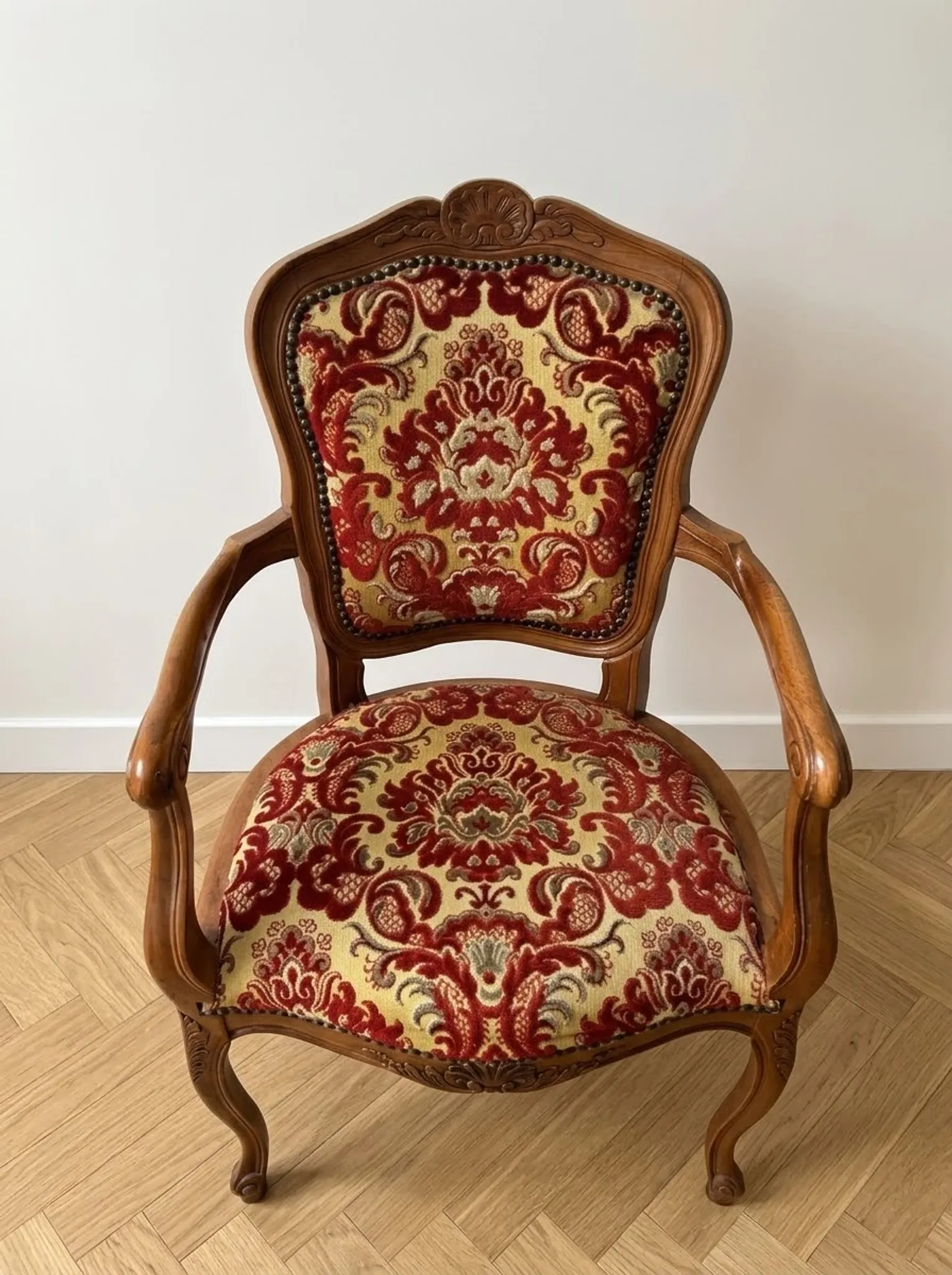 Louis XV style armchair in solid wood with red and gold damask fabric.
