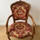 Louis XV style armchair in solid wood with red and gold damask fabric.