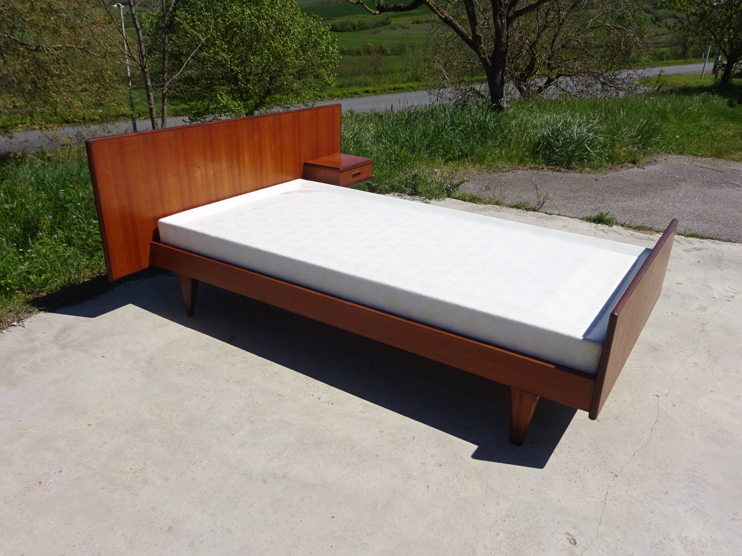 Vintage bed in teak with integrated bedside table.