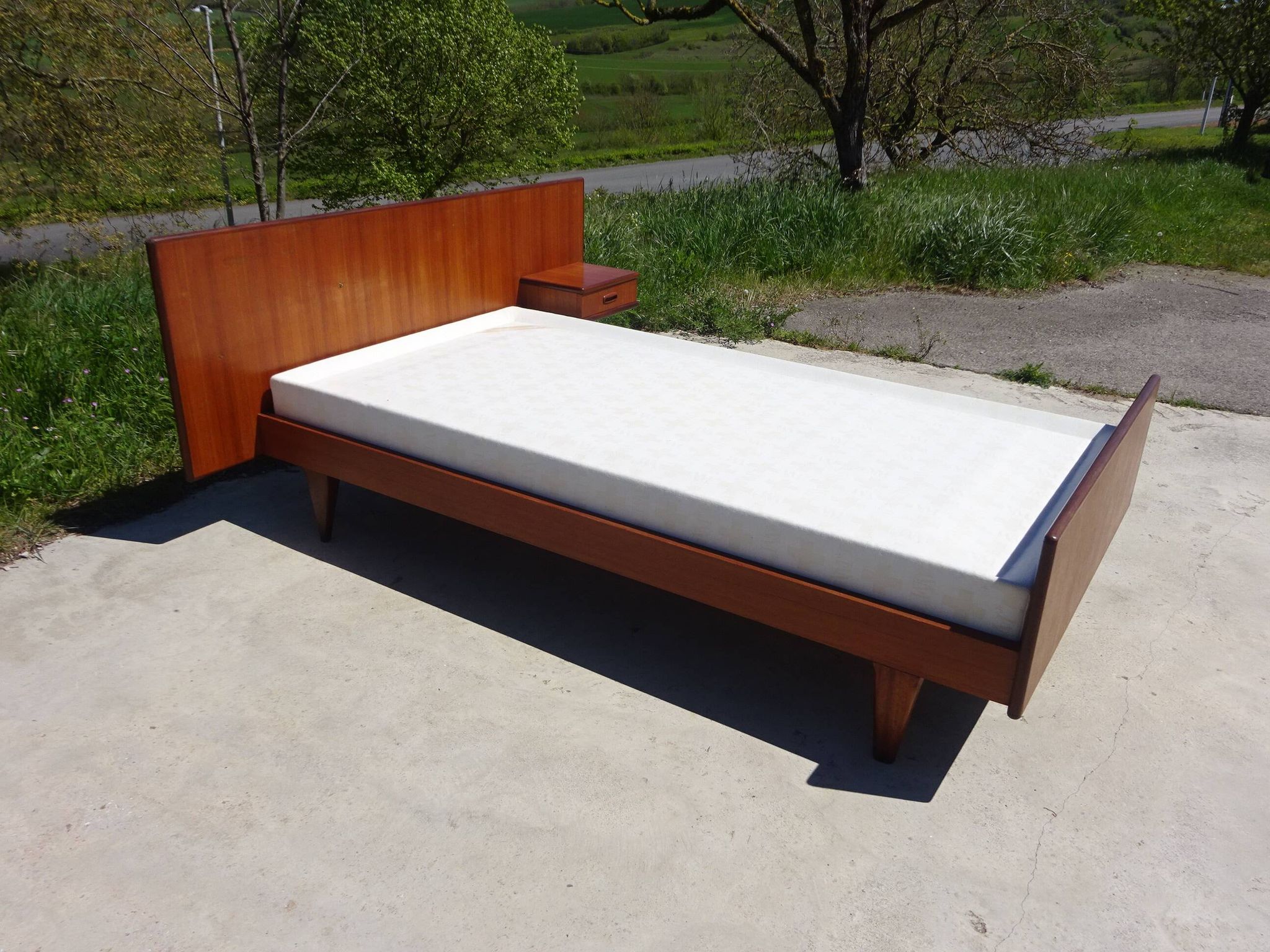 Vintage bed in teak with integrated bedside table.