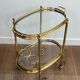 Small oval rolling table in brass with double removable trays from Maison Bagués.