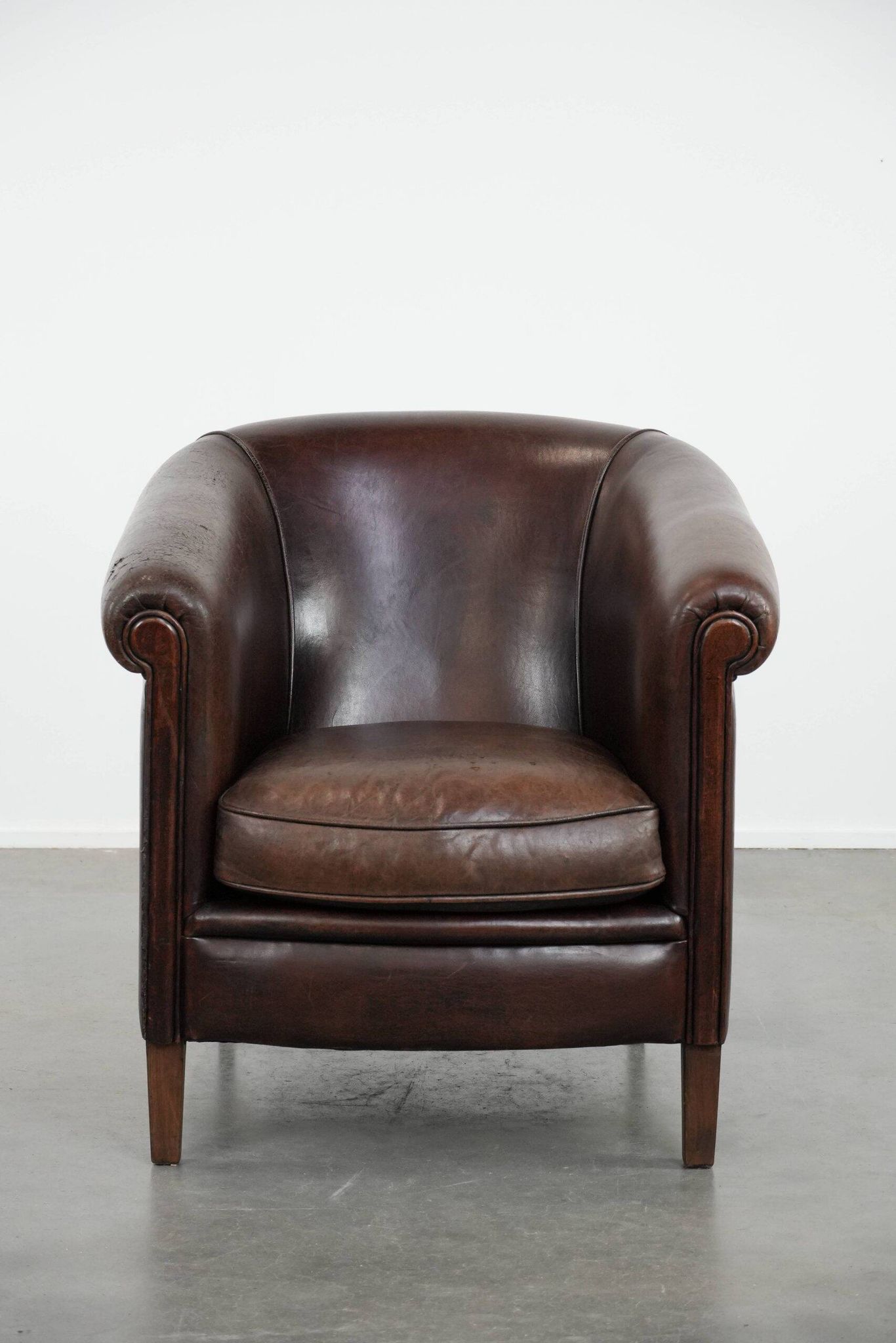 Stylish and sturdy dark brown club armchair made of sheepskin leather