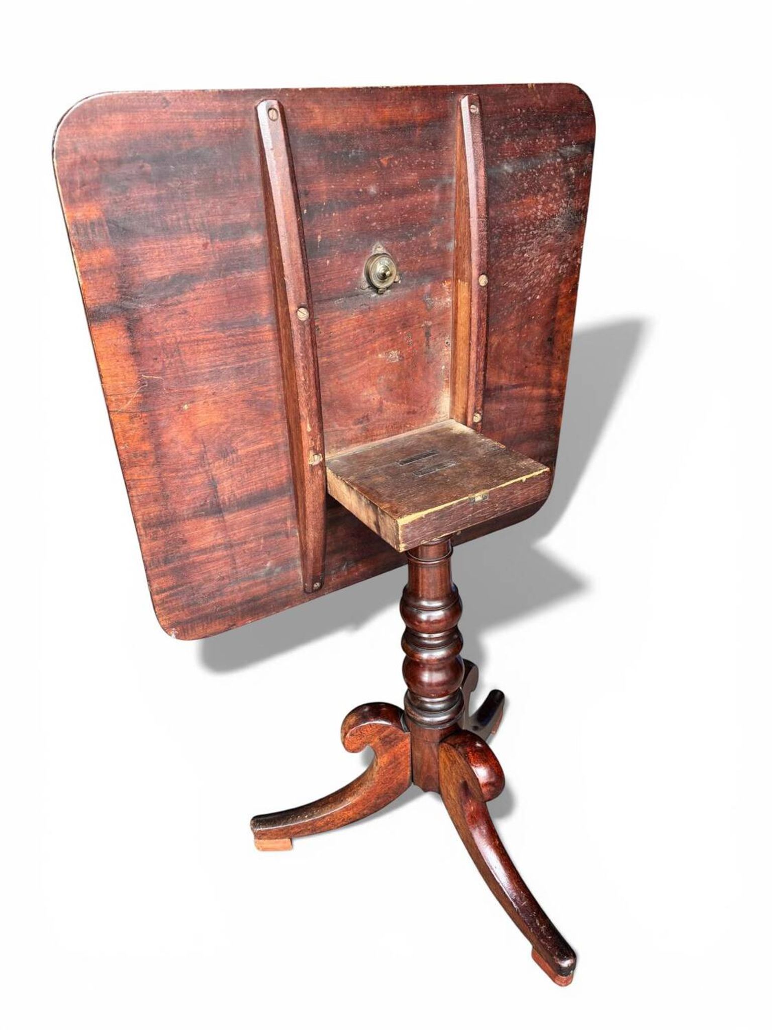19th-century solid mahogany table with a tilting top and brass mechanism.