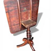 19th-century solid mahogany table with a tilting top and brass mechanism.