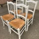 Set of 4 rustic white wooden chairs with straw seats.