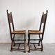 Pair of Neo-Renaissance oak chairs with straw seats, 1910