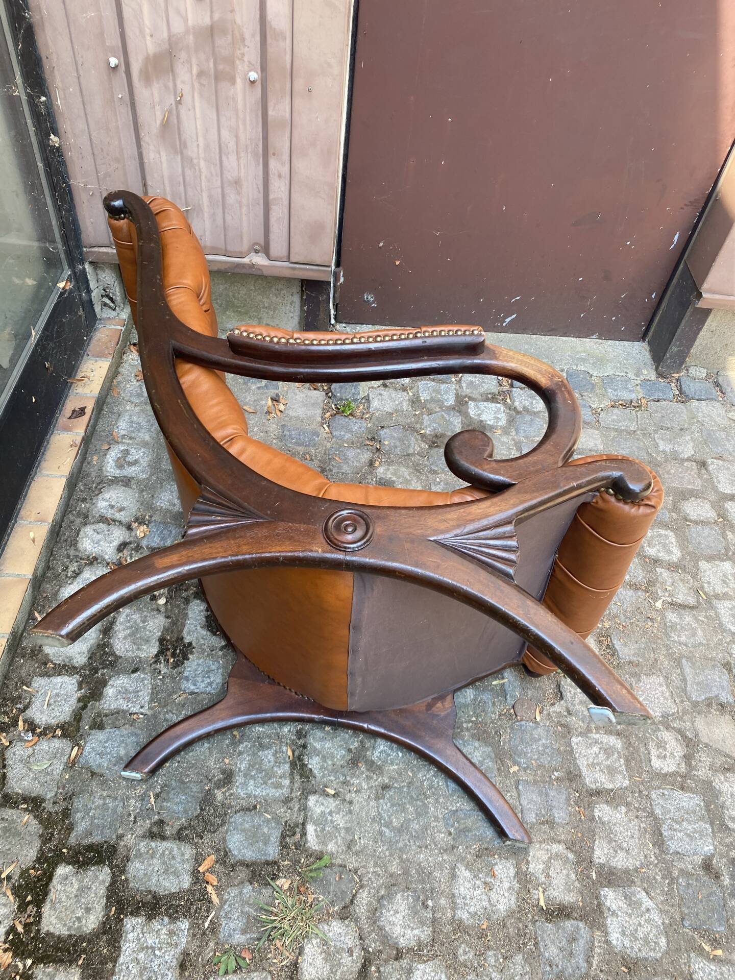 Chesterfield armchair in leather and carved solid wood