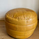 2 poufs moutarde patchwork en cuir de Sède