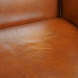 Correct, comfortable, luxurious English-style wingback armchair made of cognac-colored cow leather