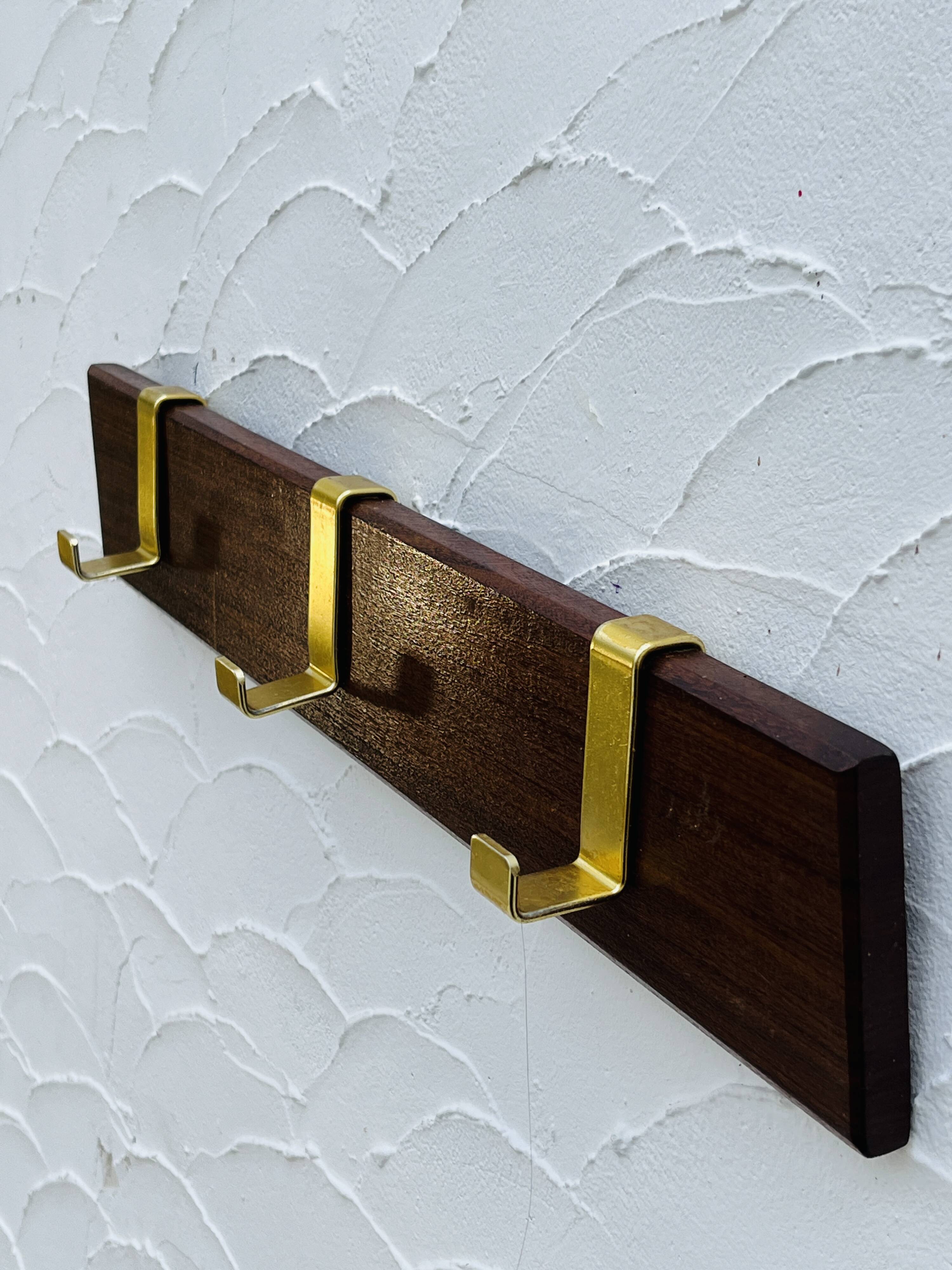 Vintage wooden and brass coat rack with 3 hooks from the 1960s.