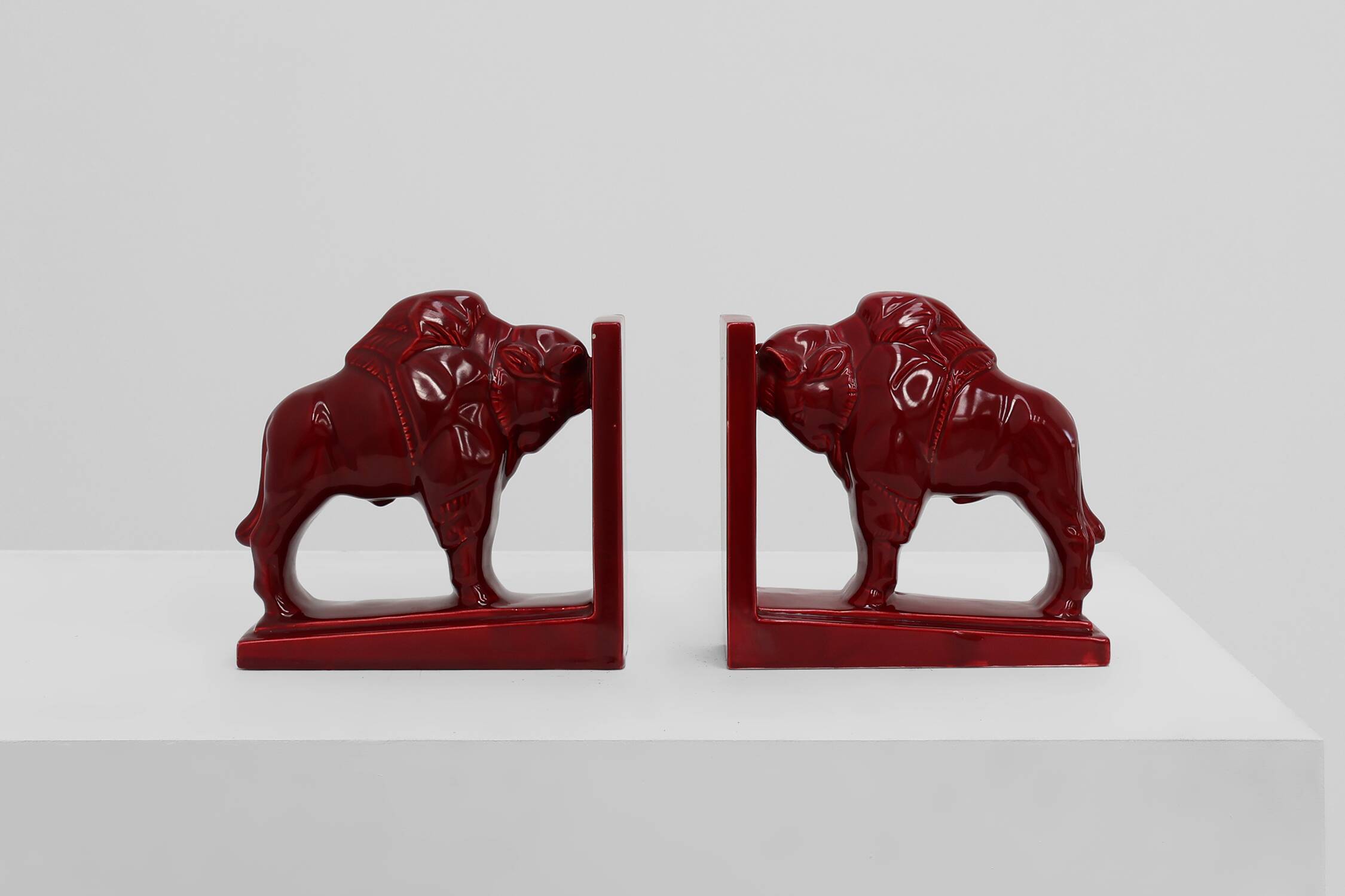 Pair of red glazed ceramic Bison ox bookends in Art Deco style, Belgium