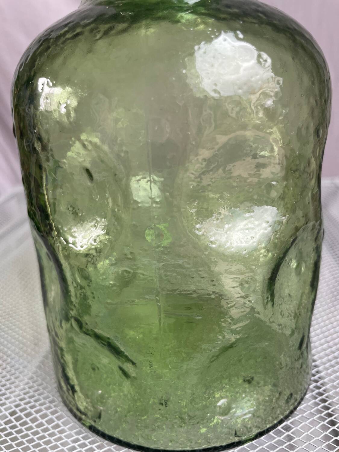 Green glass bottle with craters