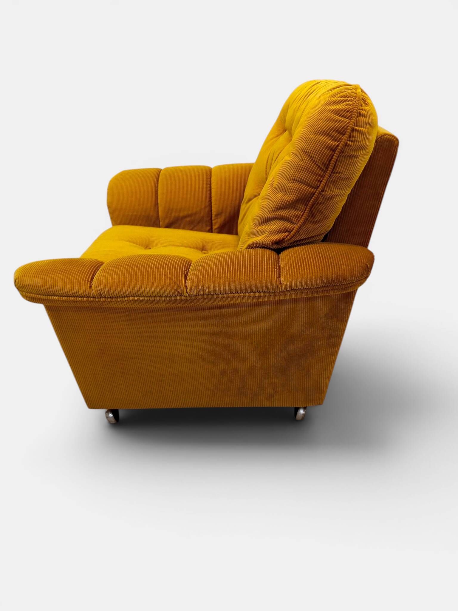 Vintage lounge chair on wheels in golden mustard corduroy 70s
