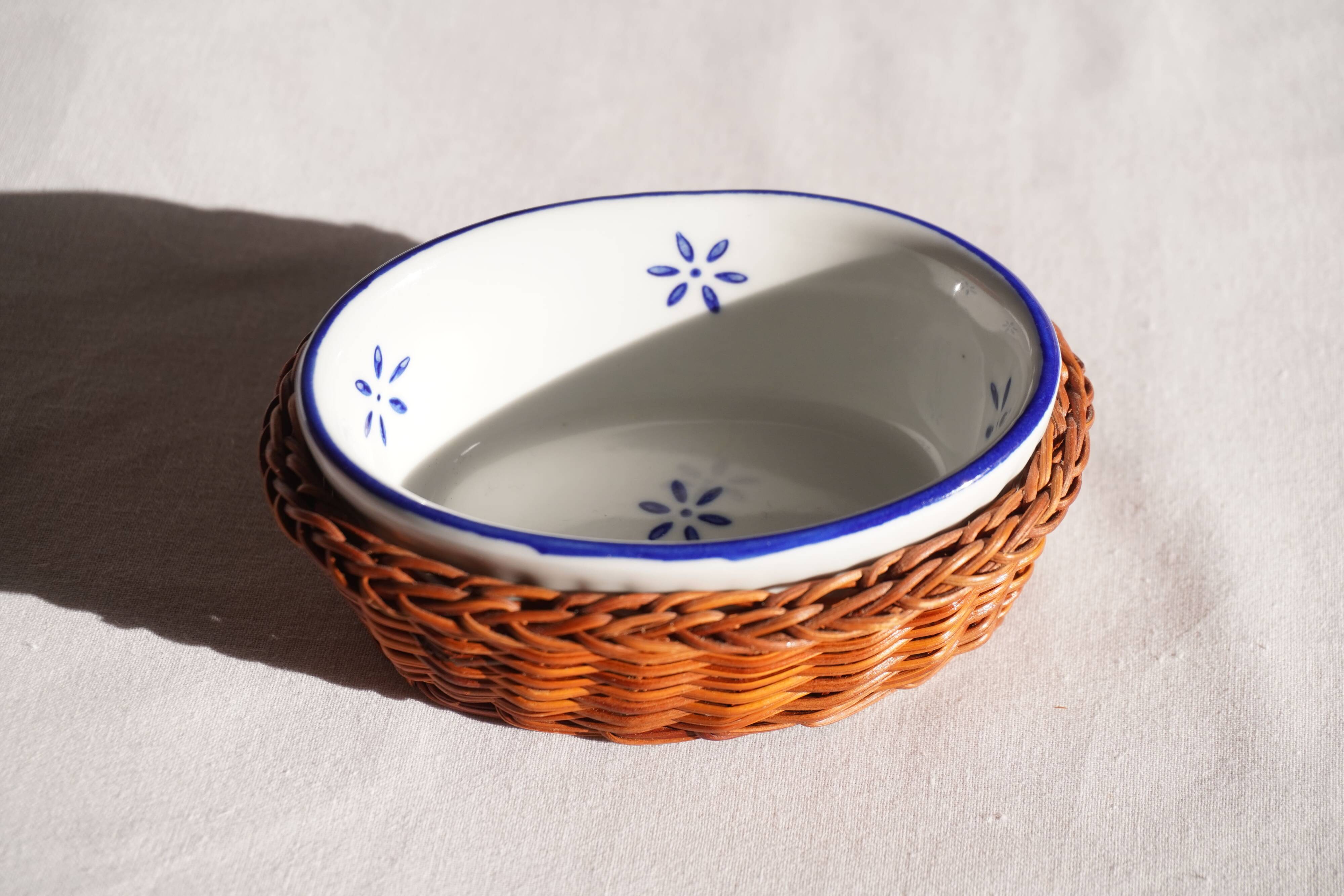 Set of 4 white porcelain dishes with blue decorations and wicker stands