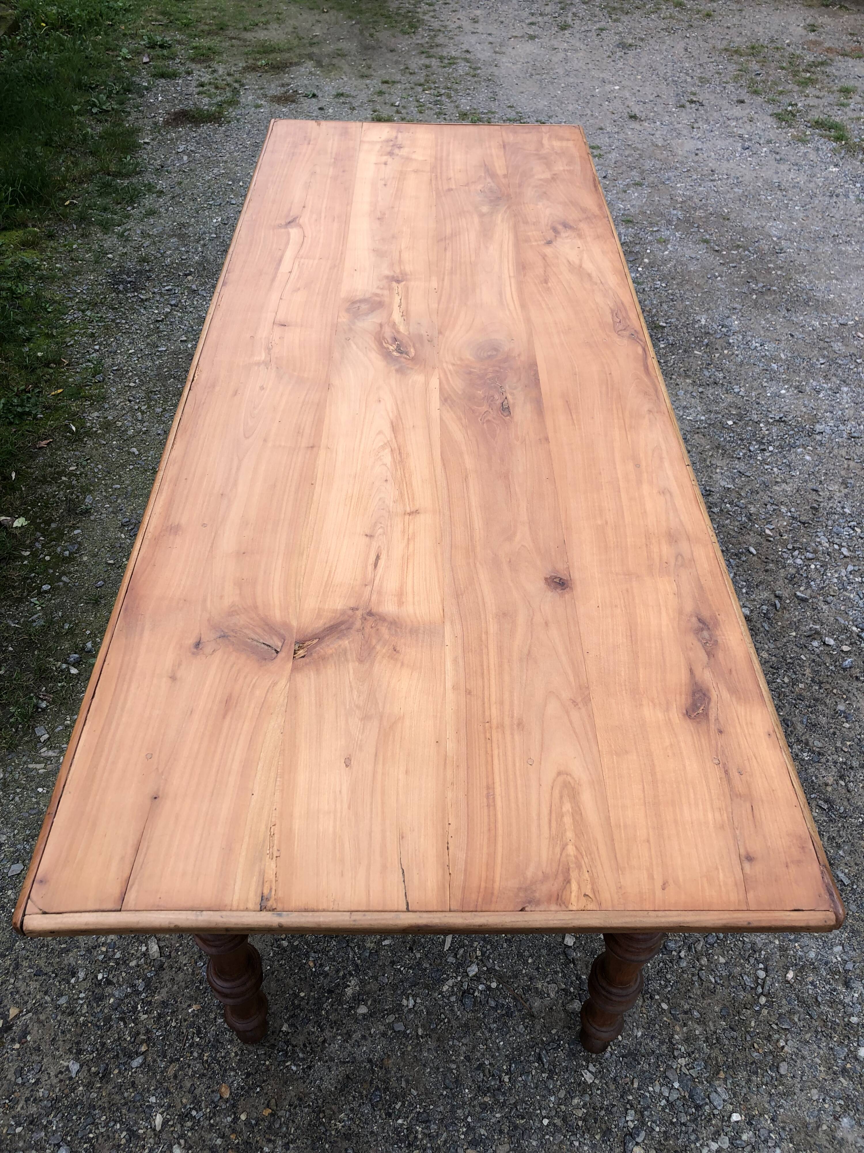 Antique Louis Philippe style farm table in solid cherry wood with 2 drawers and turned base.