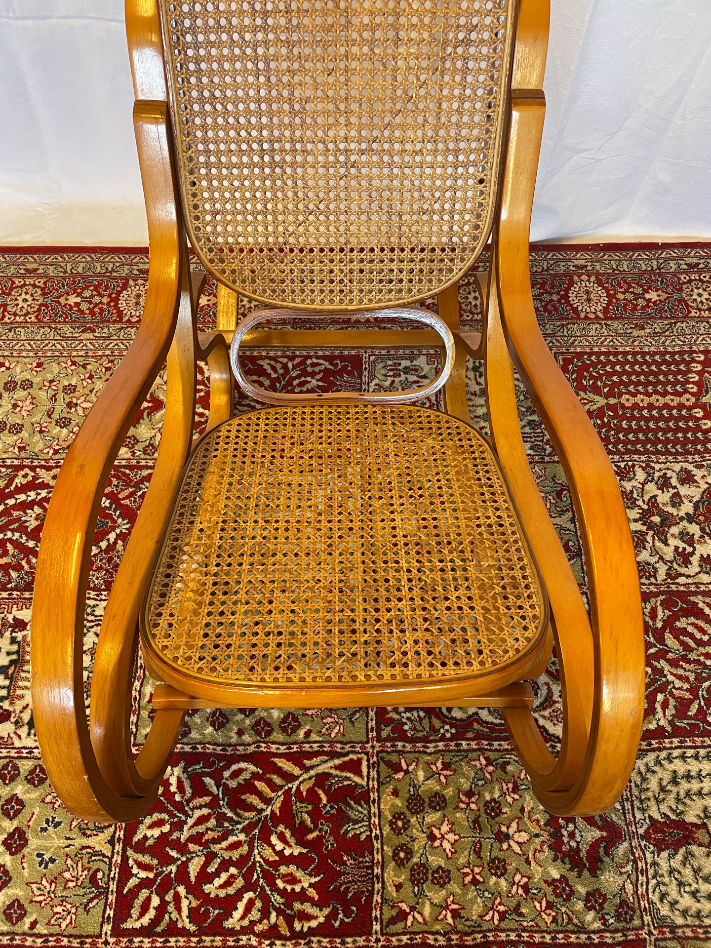 Antique rocking chair in curved wood and caning.