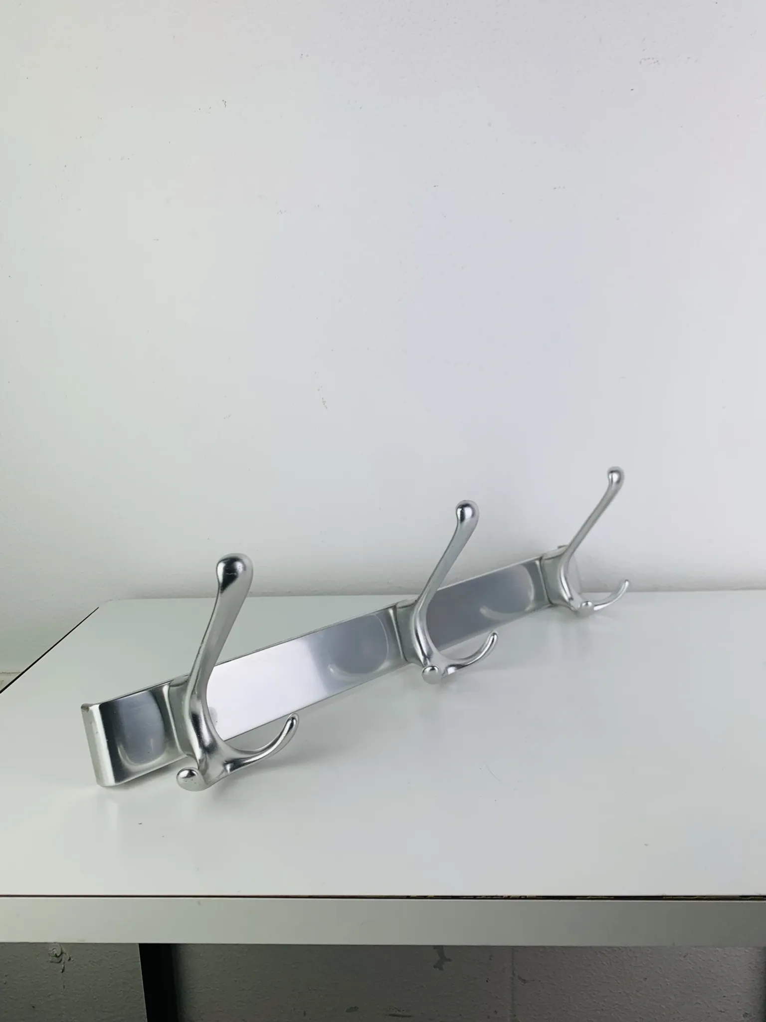 Wall-mounted coat rack, strip of 3 aluminium hooks from the 1960s.