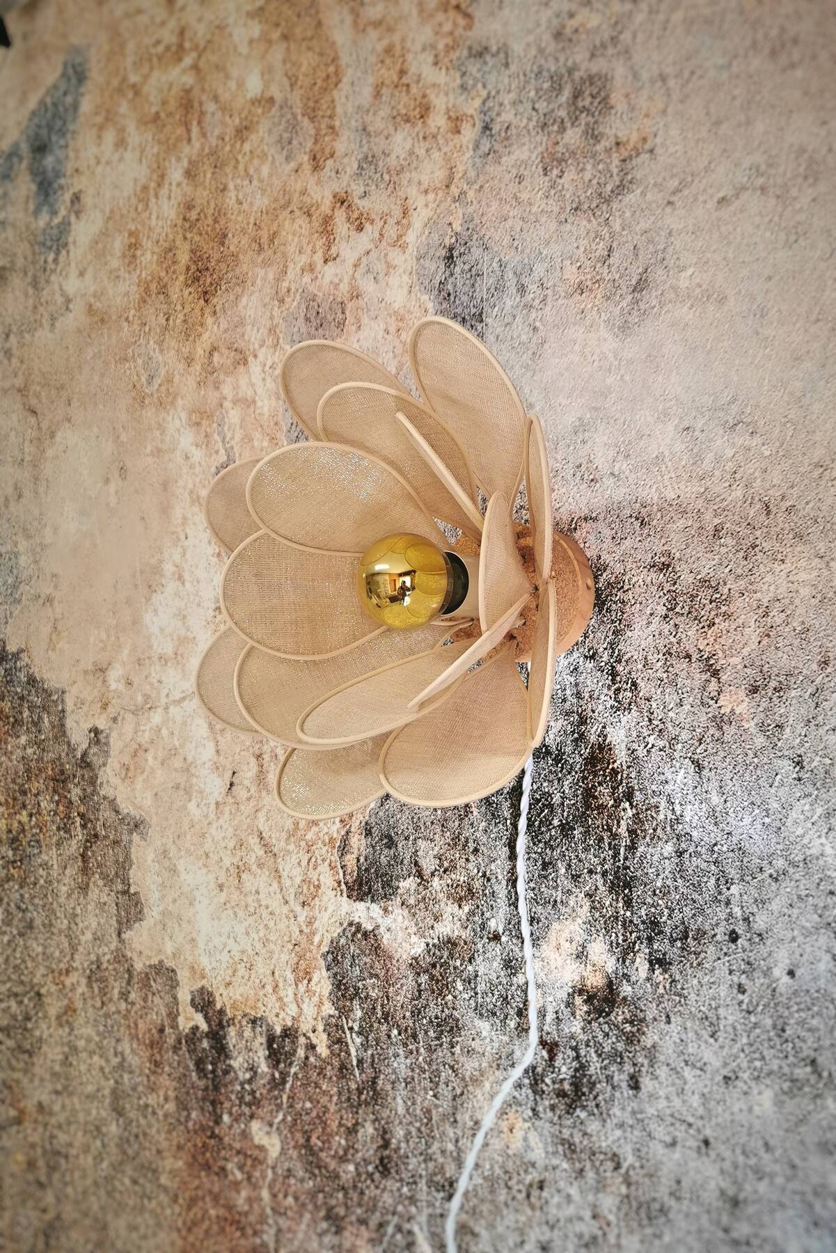 Flower wall light made of rattan petals and gold fabric
