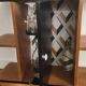 Compact bar cabinet with a pivoting door in black wood.