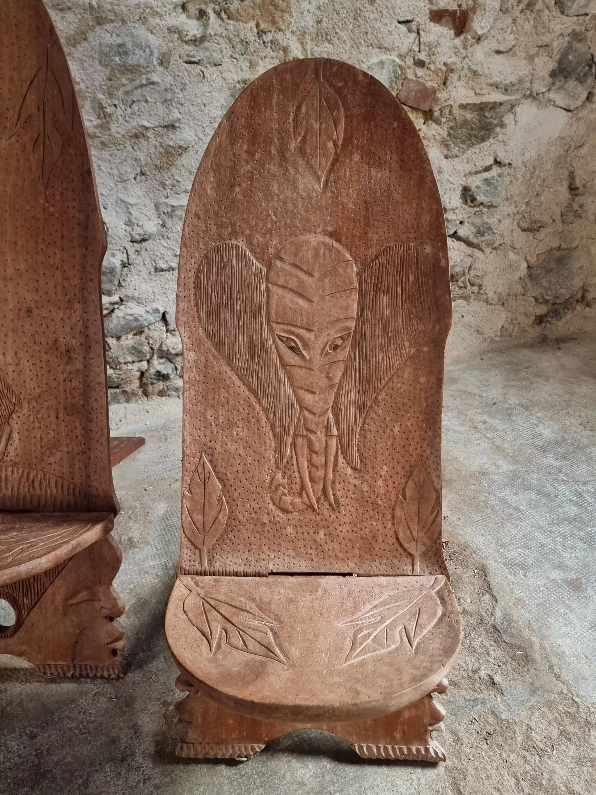 Pair of hand-carved wooden folding chairs – African origin, animal and face motifs, mid-20th century