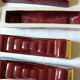 together 12 carries knives and a red enamelled earthenware bottle