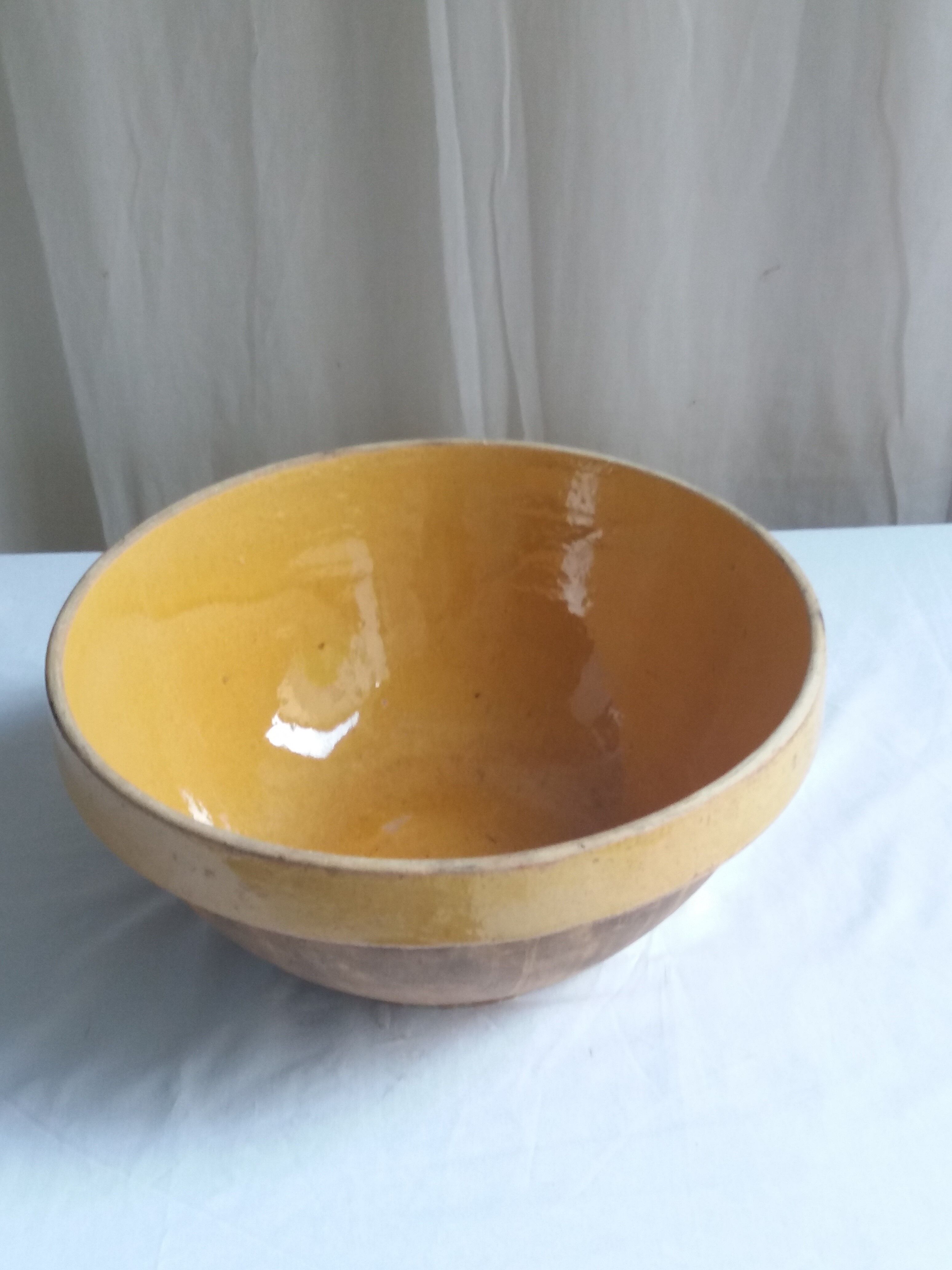 Large old salad bowl in yellow varnished earth