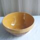Large old salad bowl in yellow varnished earth