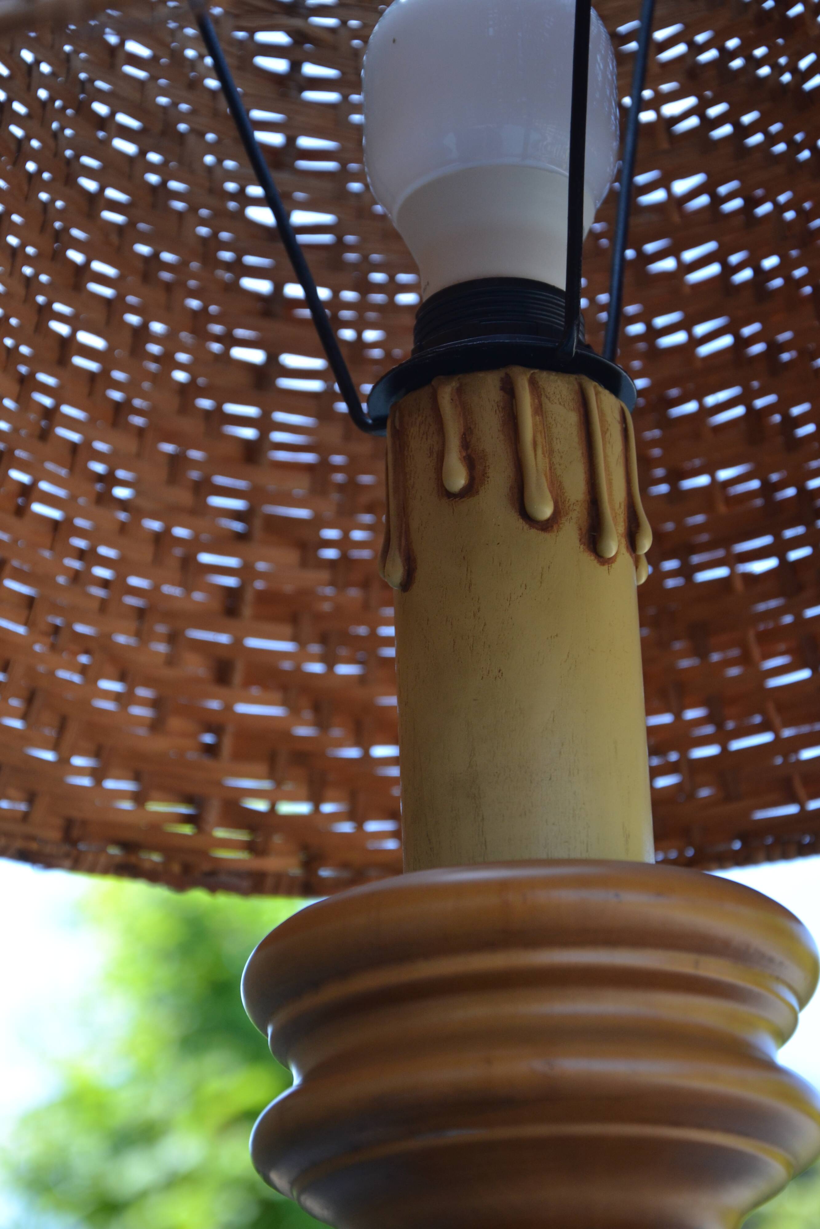 Large wooden lamp with a woven rattan shade.
