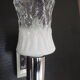 Transparent and white glass torch-type wall light.