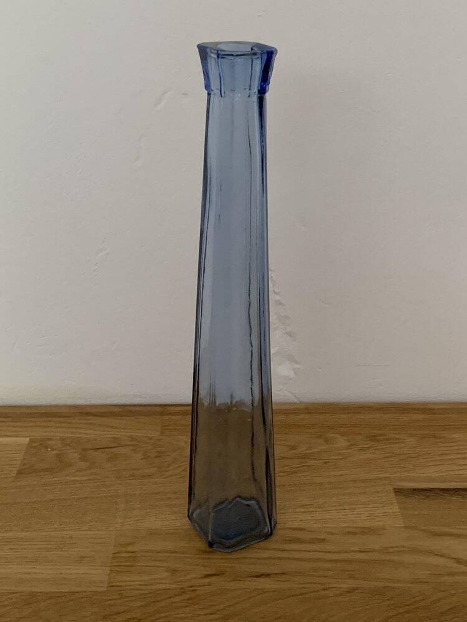 Translucent blue glass vase from the 1980s — tall prismatic silhouette, polygonal base.