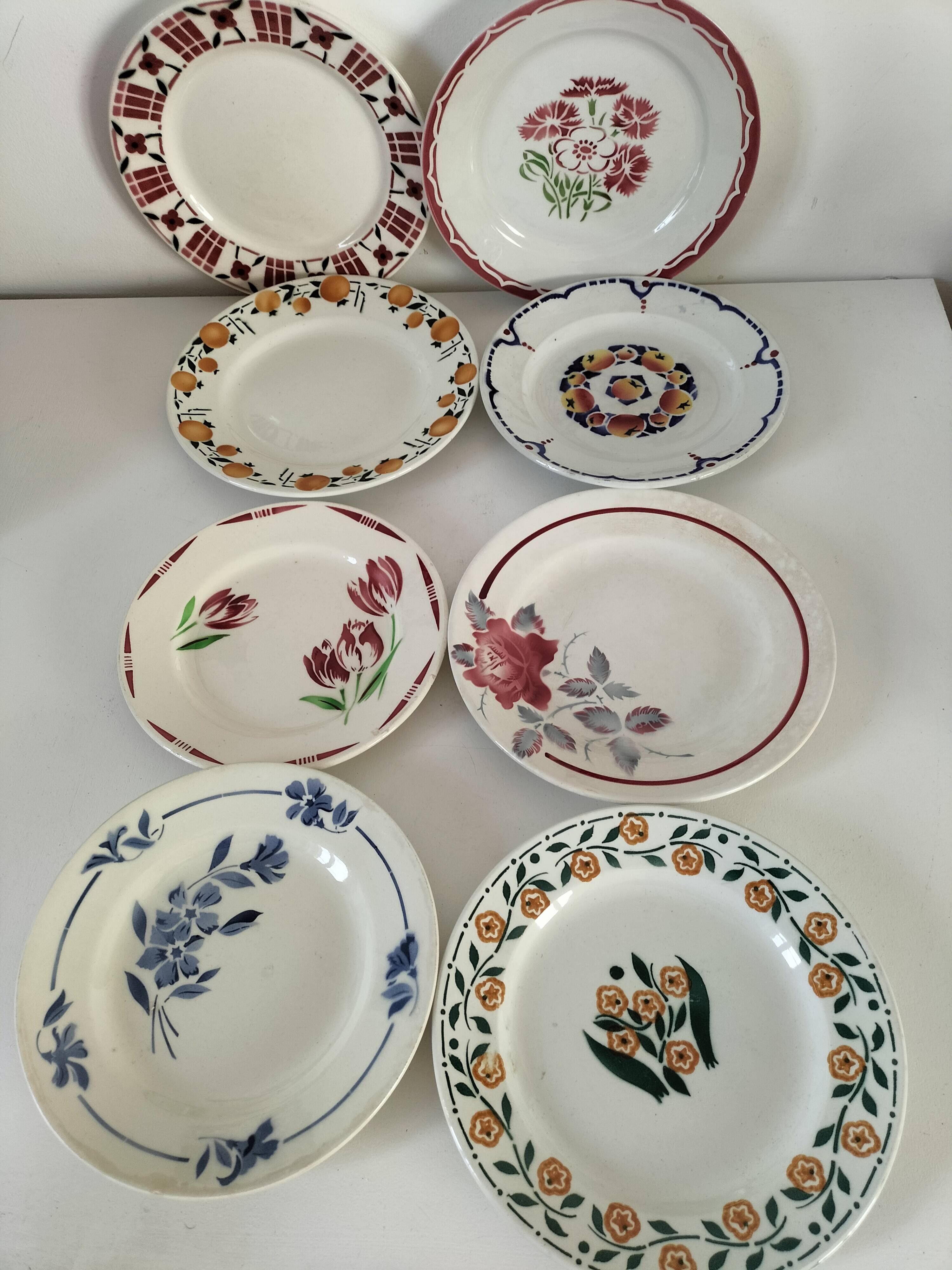 Set of 8 ironstone plates with coordinated designs.
