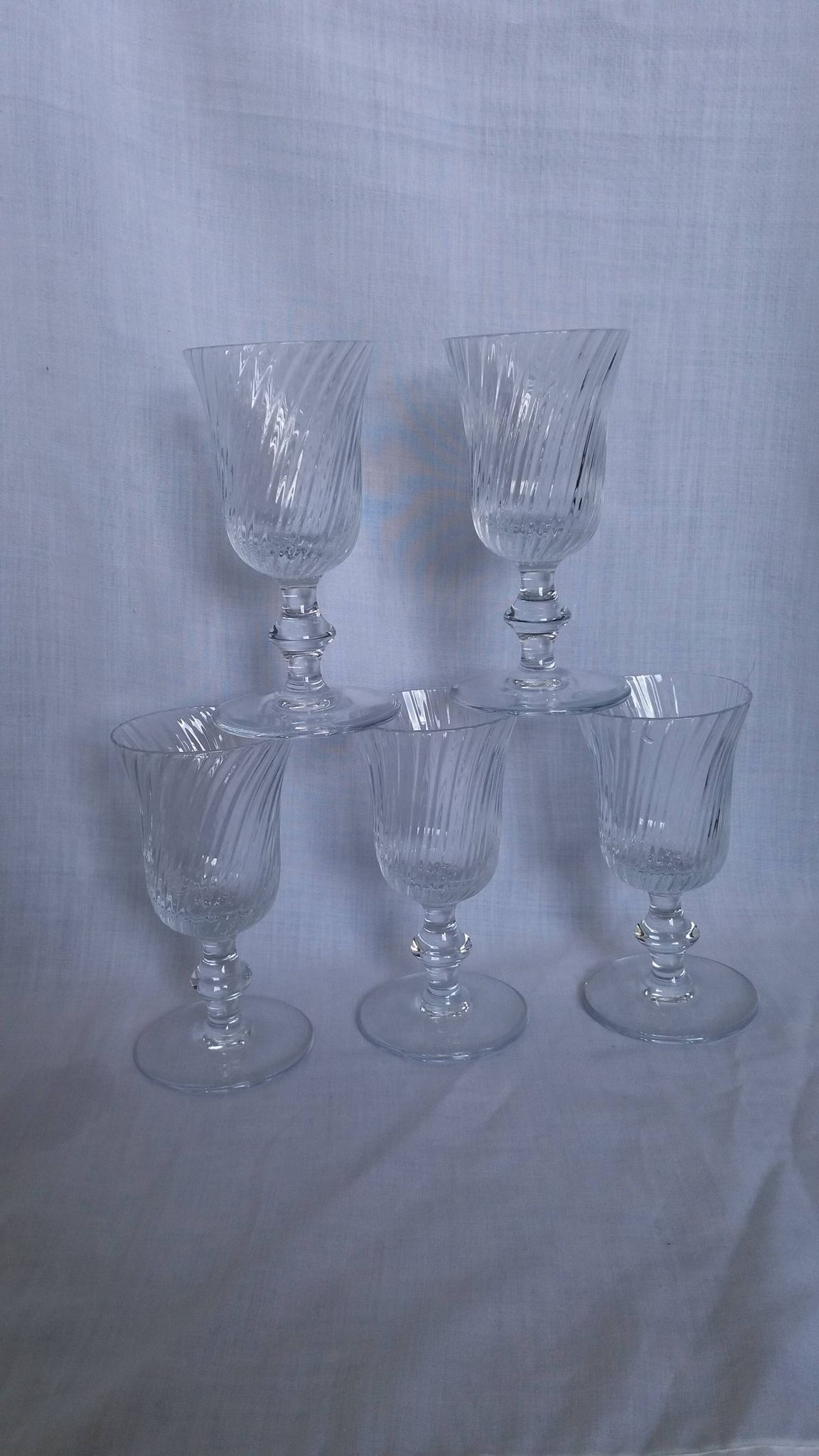 Ancient footed crystal glasses with relief twisted fluted goblets.